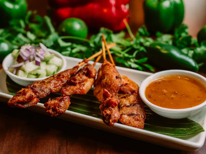 Grilled chicken satay skewers with peanut sauce and cucumber salad.